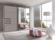 Moderner Schwebetürenschrank mit Spiegel in einem hellen Raum mit Blick auf das Wasser, von vorne betrachtet.