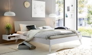 Modernes Schlafzimmer mit gepolstertem Kopfteil, seitlicher Perspektive, helle Farben und minimalistisches Design.