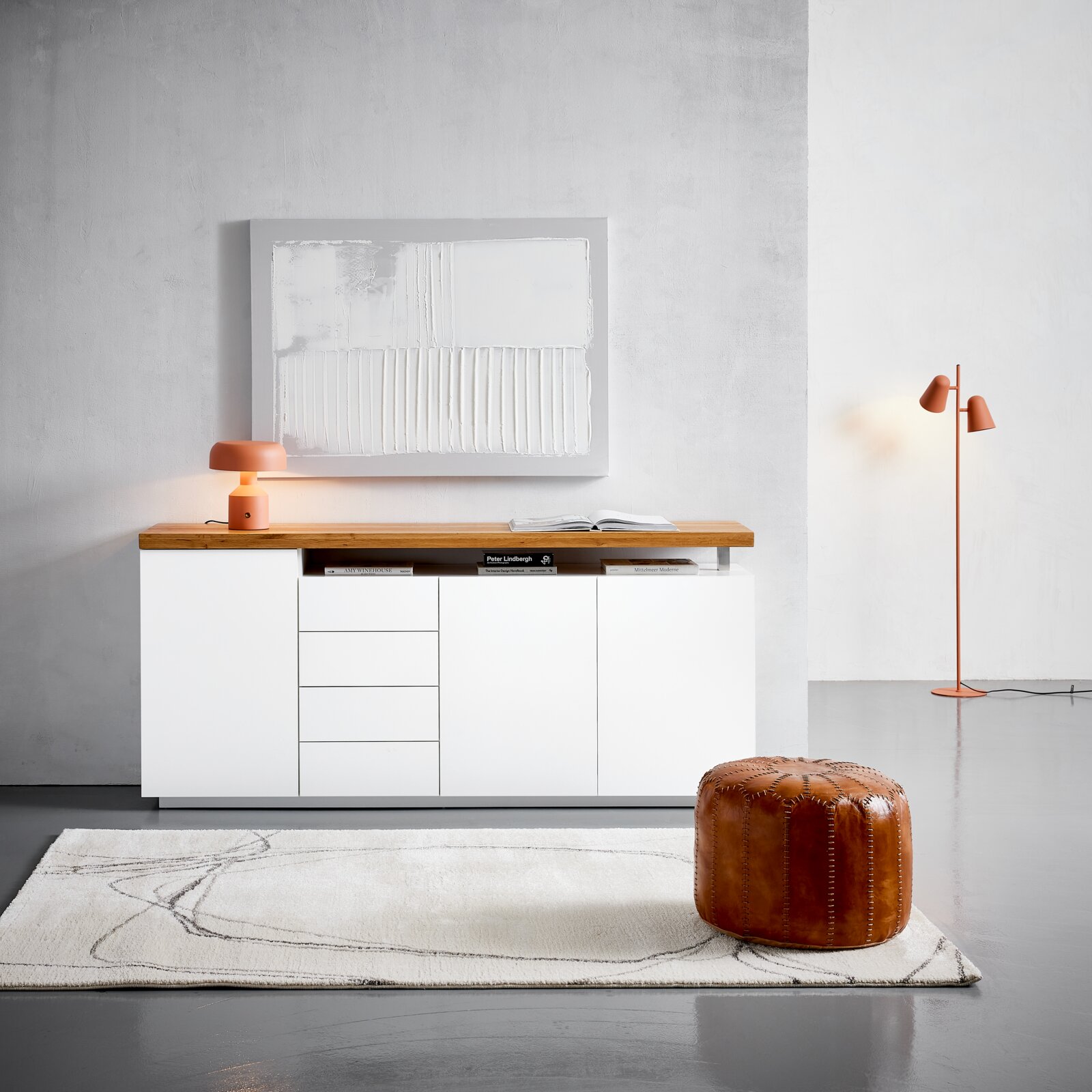 Novel XL-Sideboard MORO Frontale Ansicht eines modernen XL-Sideboards in Weiß mit Holzplatte, dekoriert mit einer orangefarbenen Lampe und Kunstwerk an der Wand.