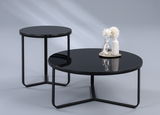 Zwei moderne Tische mit schwarzer Glasplatte und Metallgestell, einer als Beistelltisch und der andere als Couchtisch, aus seitlicher Perspektive fotografiert.