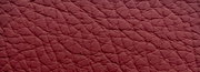 Nahaufnahme einer strukturierten, roten Lederoberfläche, perspektivisch von oben betrachtet.