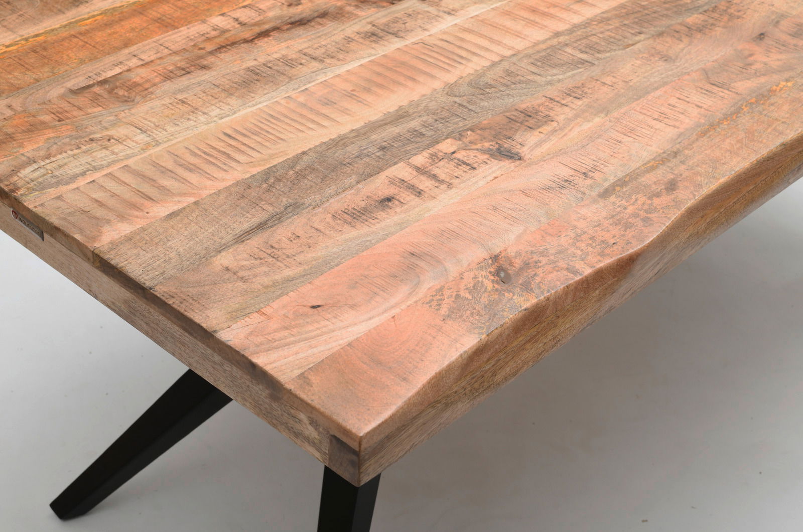 Nahaufnahme eines Esstisches aus Holz mit natürlicher Maserung und schwarzem Metallgestell, Perspektive von oben.