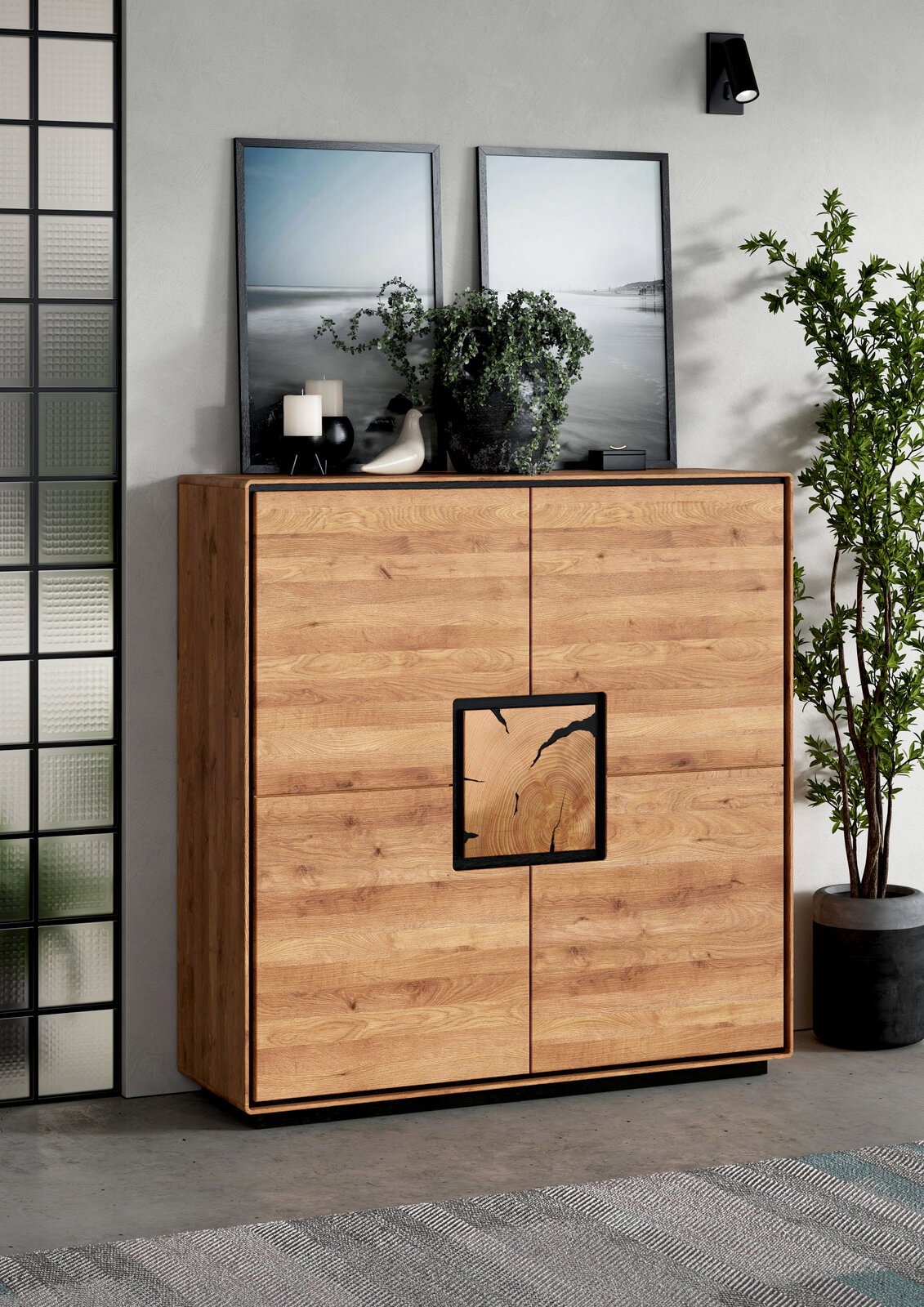Moderne Holz-Kommode/Sideboard in Eichenoptik mit vier Türen und schwarzem Metallrahmen, frontal aus leicht schräger Perspektive im Wohnraum inszeniert, dekoriert mit Bildern, Kerzen und Pflanzen.