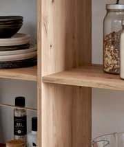 Close-up van een houten plank met serviesgoed en voorraadpotten, gezien vanaf de zijkant.