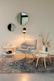 Moderne schommelstoel in een stijlvol ingerichte kamer, zijaanzicht.