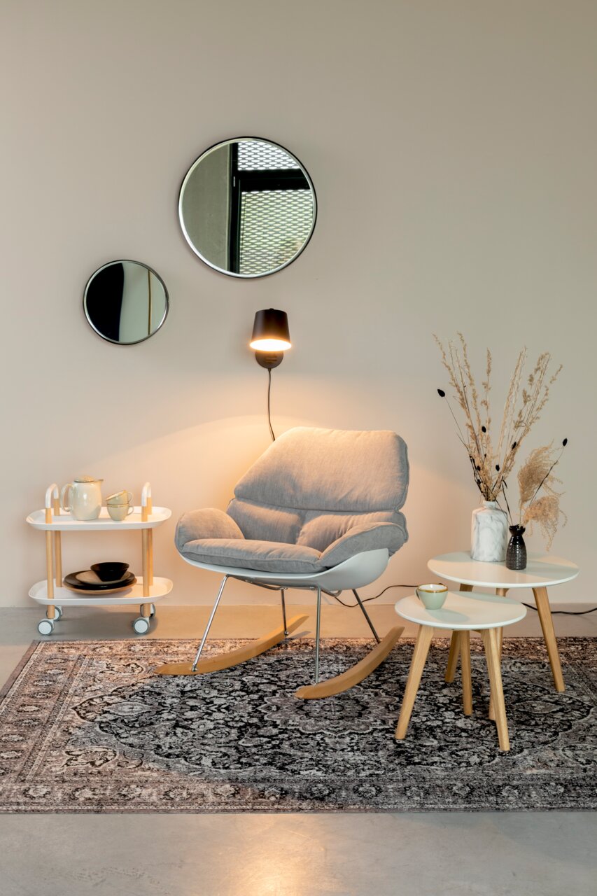 Moderne schommelstoel in een stijlvol ingerichte kamer, zijaanzicht.
