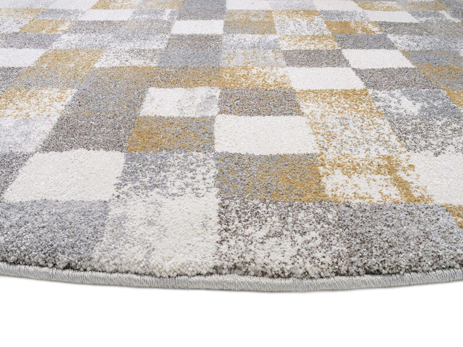 Nahaufnahme eines Frisé-Teppichs mit einem modernen, karierten Muster in Grau-, Weiß- und Gelbtönen, aus einer seitlichen Perspektive fotografiert.
