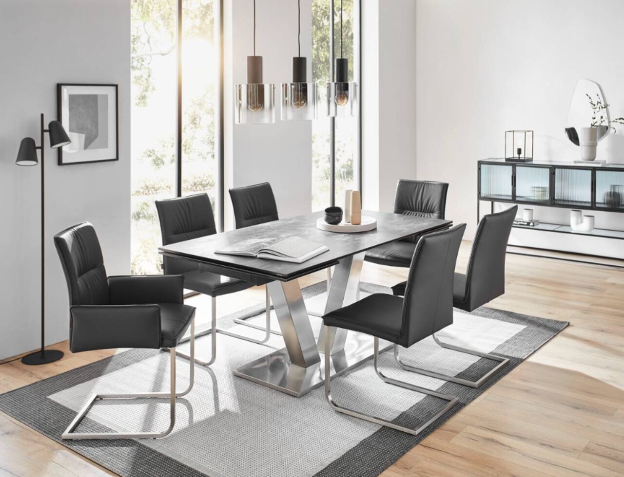 Novel Esstisch GRANADA Moderner Esstisch mit schwarzer Tischplatte und sechs schwarzen Stühlen in einem hellen, stilvollen Esszimmer. Perspektive von der Seite.