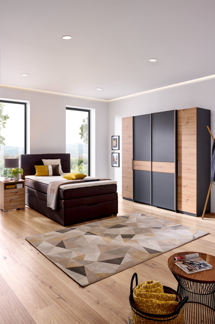 Modernes Boxspringbett in einem stilvollen Schlafzimmer mit Holzfußboden, seitliche Perspektive.