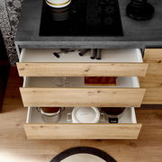 Küchenblock mit offenen Schubladen aus Holzoptik, gefüllt mit Küchenutensilien, aus der Vogelperspektive betrachtet.