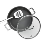 Schwarze Bratpfanne mit zwei Metallgriffen, Glasdeckel und Edelstahl-Pfannenwender, aus schräger Draufsicht vor weißem Hintergrund