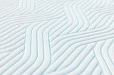 Nahaufnahme eines Tempur Topper Soft PRO PLUS SMARTCOOL mit wellenförmigem Muster in diagonaler Perspektive.