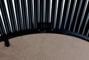 Rückansicht eines runden Spiegels mit schwarzem Metallrahmen und dekorativen Stäben.