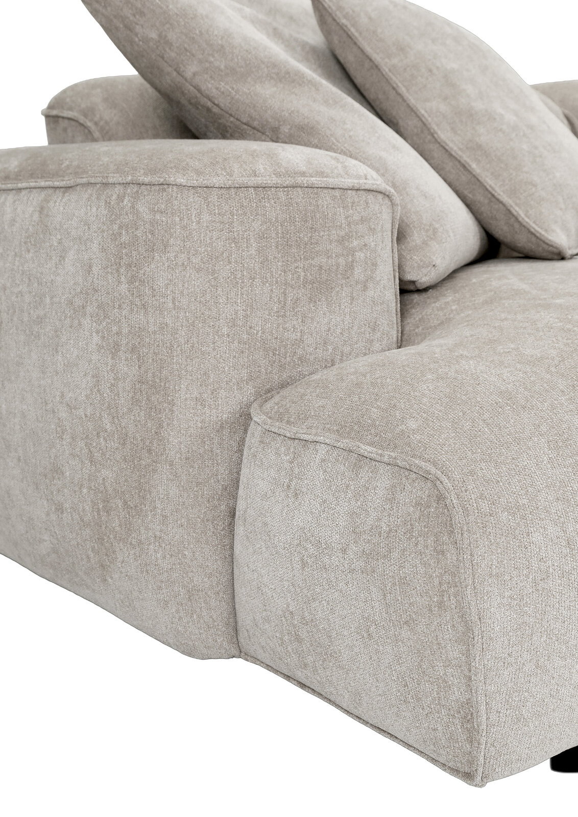 Detailaufnahme eines hellbeigen Stoffsofas mit breiter Armlehne und weichen Rückenkissen, Perspektive schräg von vorne links