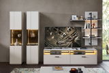 Moderne Wandkombination in Weiß mit integrierter Beleuchtung, bestehend aus zwei hohen Schränken, einem TV-Board und einem Wandregal. Frontalansicht.