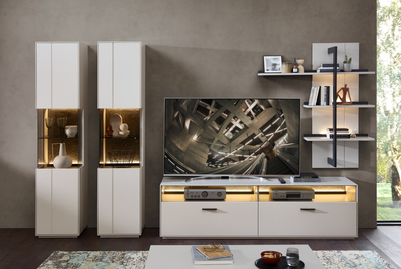 Zurbrüggen Wandkombination COMO Moderne Wandkombination in Weiß mit integrierter Beleuchtung, bestehend aus zwei hohen Schränken, einem TV-Board und einem Wandregal. Frontalansicht.