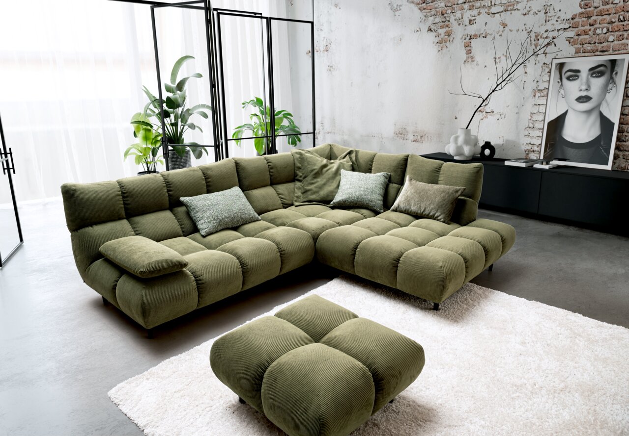 Grüne Eckgarnitur mit Hocker in modernem Wohnzimmer, seitliche Perspektive