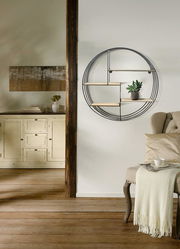 Rundes Wandregal aus Metall mit Holzablagen, seitliche Perspektive, dekoriert mit einer kleinen Pflanze.