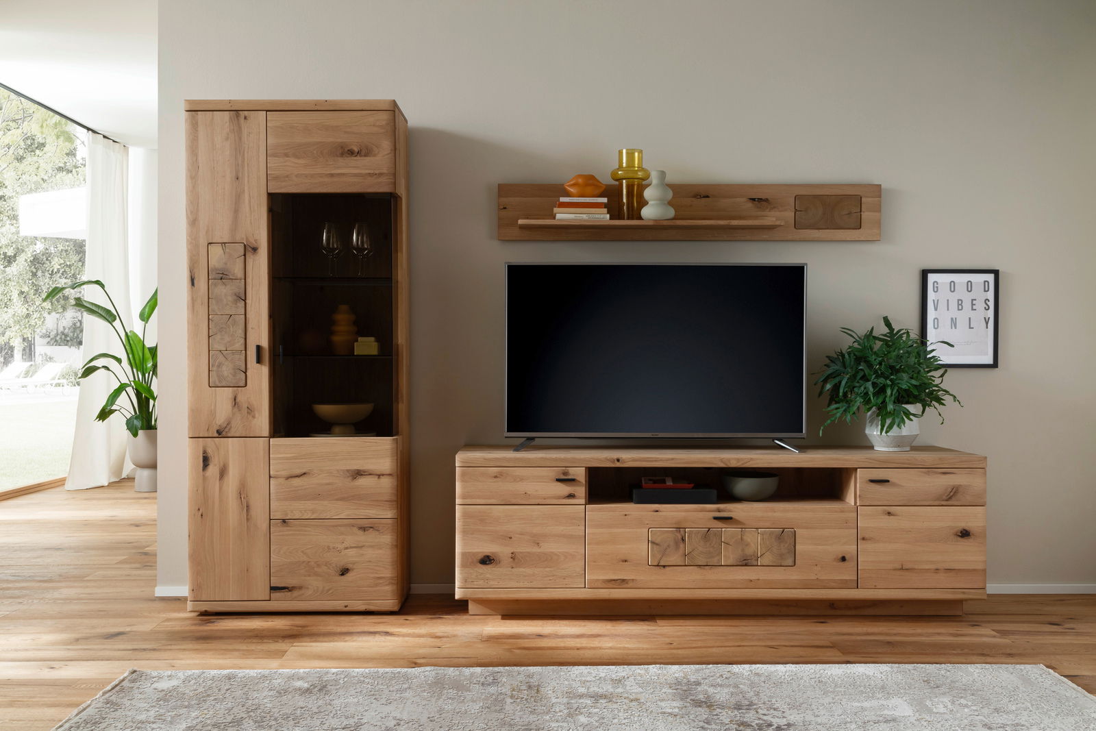 Linea Natura Wandkombination PHÖNIX Frontale Ansicht einer modernen Wandkombination aus Holz mit TV-Schrank, Regal und Vitrine, dekoriert mit Pflanzen und Accessoires.