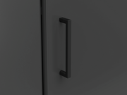 Nahaufnahme eines schwarzen Türgriffs an einer dunklen Eckkommode, seitliche Perspektive