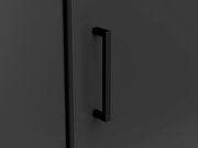 Nahaufnahme eines schwarzen Türgriffs an einer dunklen Eckkommode, seitliche Perspektive