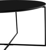 Moderne salontafel met een rond zwart tafelblad en een filigraan metalen onderstel, zijaanzicht