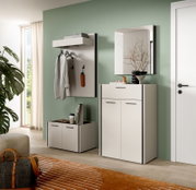 Modernes Flur-Set mit weißer Garderobenpaneele samt Ablage und Haken, passendem Schuhschrank und Spiegel an mintgrüner Wand, fotografiert in leicht schräger Frontansicht aus Augenhöhe.
