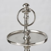Nahaufnahme einer silbernen Deko-Etagere mit drei Ebenen, elegantes Design mit rundem Griff oben, seitliche Perspektive.