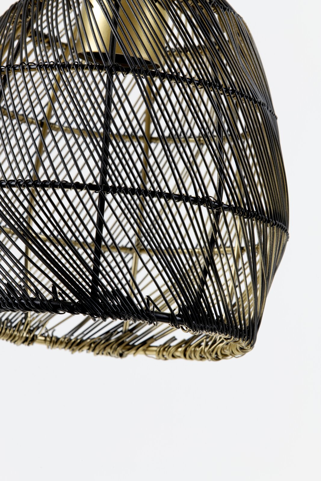 Detailopname van onderaf van een decoratieve lampenkap met zwart metalen draadwerk en goudkleurige accenten tegen een witte achtergrond