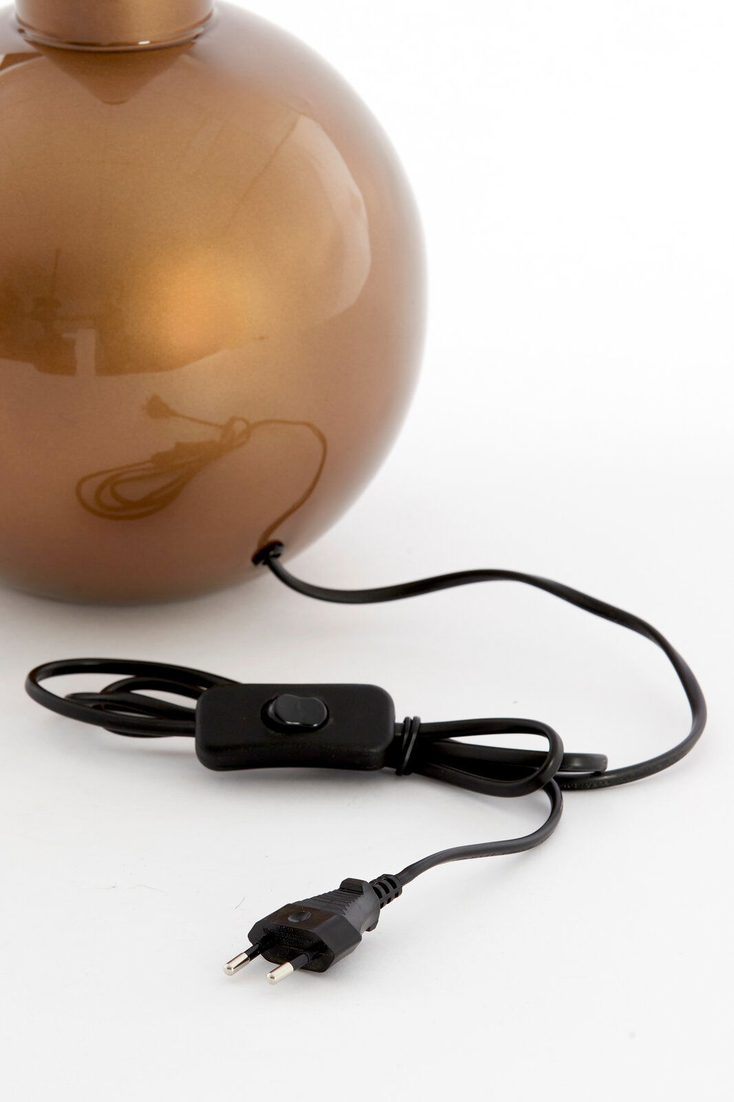 Nahaufnahme eines runden, bronzefarbenen Lampenfußes mit einem schwarzen Kabel und Schalter, seitliche Perspektive.