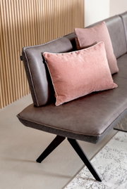 Eckbank in seitlicher Perspektive mit braunem Lederbezug und rosa Kissen, modernes Design mit schwarzen Metallbeinen.