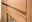 Nahaufnahme eines Highboards aus Holz mit Glasfront, seitliche Perspektive