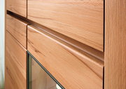 Nahaufnahme eines Highboards aus Holz mit Glasfront, seitliche Perspektive
