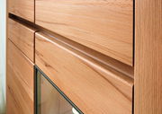 Nahaufnahme eines Highboards aus Holz mit Glasfront, seitliche Perspektive