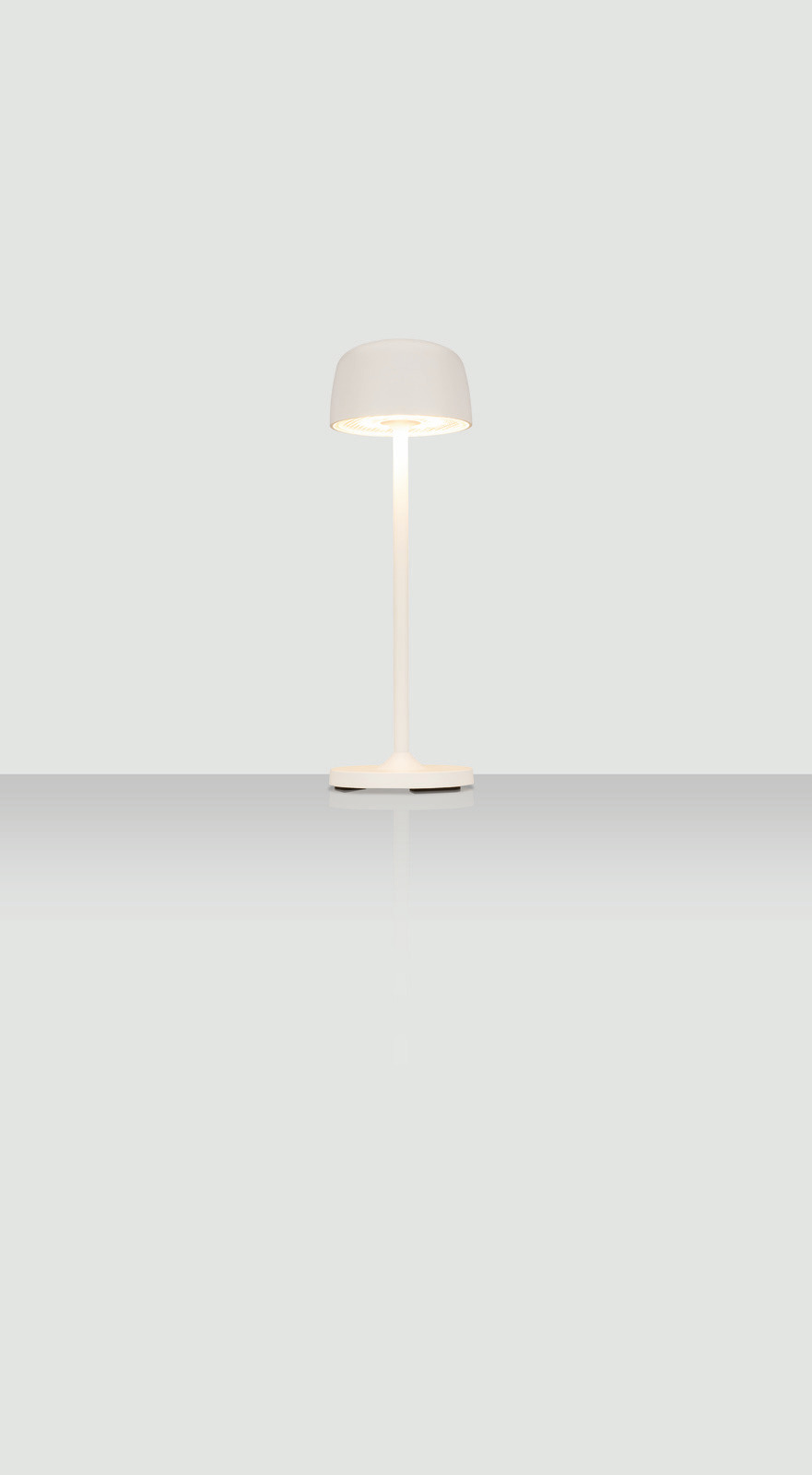 Moderne Akku-Tischleuchte in Weiß, frontal abgebildet auf einer reflektierenden Oberfläche.