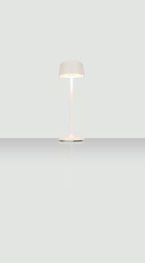 Moderne Akku-Tischleuchte in Weiß, frontal abgebildet auf einer reflektierenden Oberfläche.