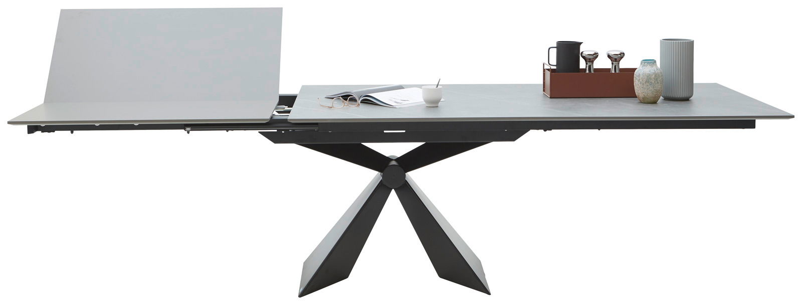 Moderner Esstisch mit ausziehbarer Tischplatte und geometrischem Fußgestell, seitliche Perspektive.