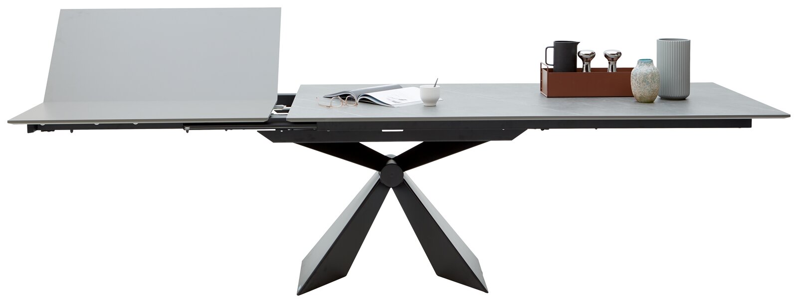 Moderner Esstisch mit ausziehbarer Tischplatte und geometrischem Fußgestell, seitliche Perspektive.