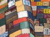 Patchwork-Lederteppich aus verschiedenen bunten Etiketten, perspektivisch von der Seite fotografiert.