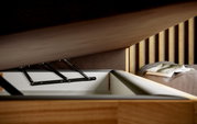 Nahaufnahme eines geöffneten Boxspringbetts mit Stauraum, seitliche Perspektive