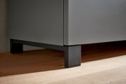 Nahaufnahme eines modernen Garderoben-Sets mit schwarzem Metallfuß auf Holzfußboden, seitliche Perspektive.
