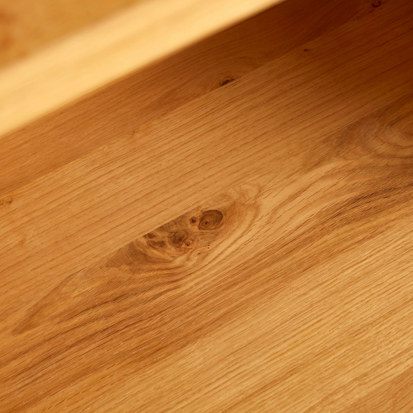 Nahaufnahme der Holzmaserung eines Regals aus der Perspektive von oben.