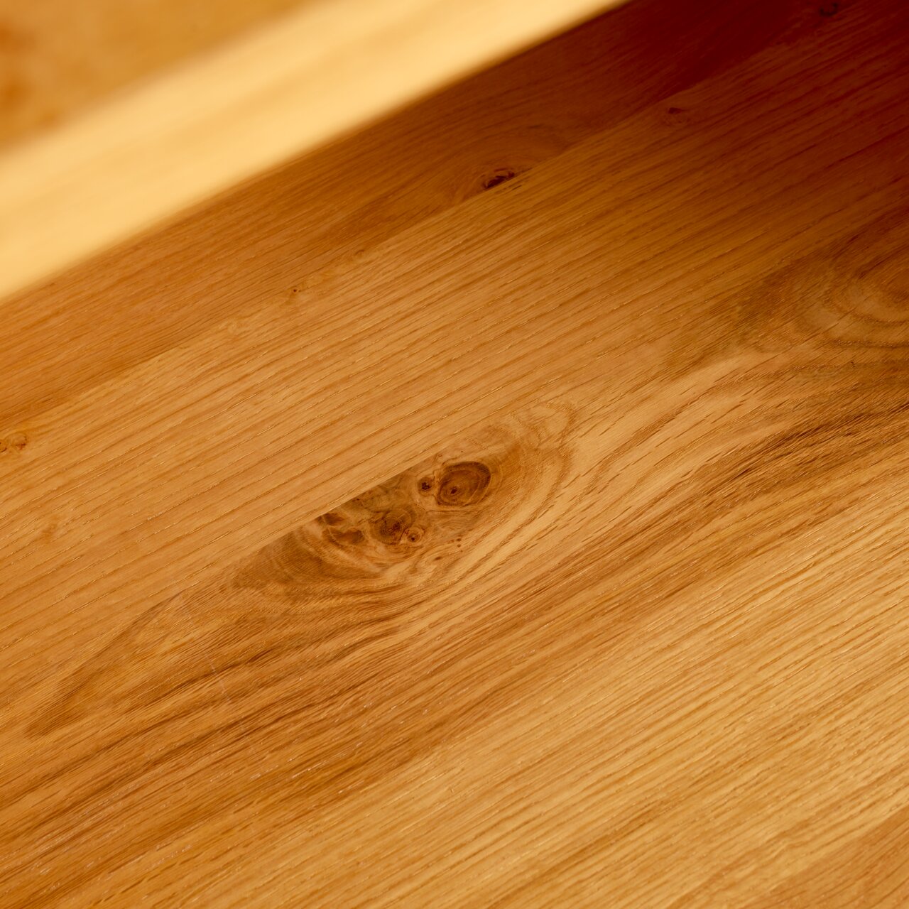 Nahaufnahme der Holzmaserung eines Regals aus der Perspektive von oben.