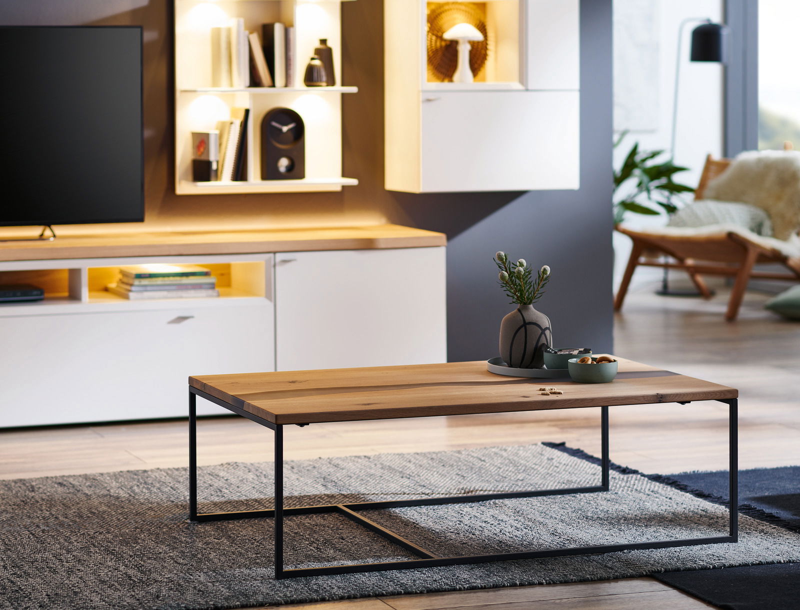 Moderner Couchtisch mit Holzplatte und schwarzem Metallgestell, seitliche Perspektive in einem stilvoll eingerichteten Wohnzimmer.