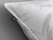 Nahaufnahme eines weißen Kopfkissenbezugs mit dezentem Blattmuster und ZO! HOME Etikett.