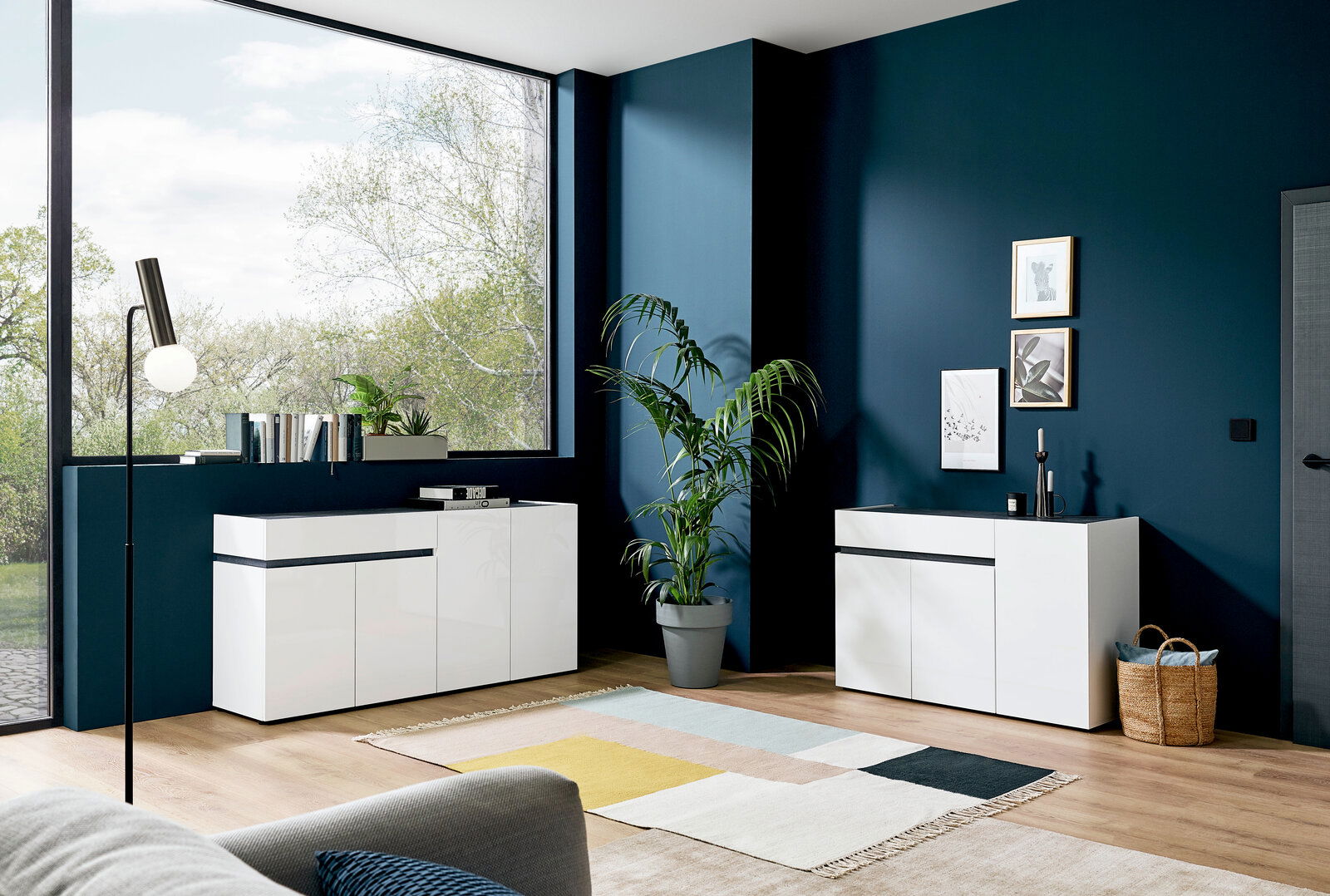 Moderner weißer Sideboard in einem stilvollen Wohnzimmer mit großen Fenstern und Pflanzen, seitliche Perspektive