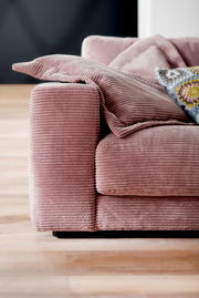 Nahaufnahme eines rosa Cord-Sofas mit Kissen, seitliche Perspektive