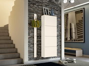Moderner Hängeschuhschrank in Cremeweiß an einer Steinwand, mit seitlicher Perspektive. Daneben eine Hakenleiste mit grüner Tasche.