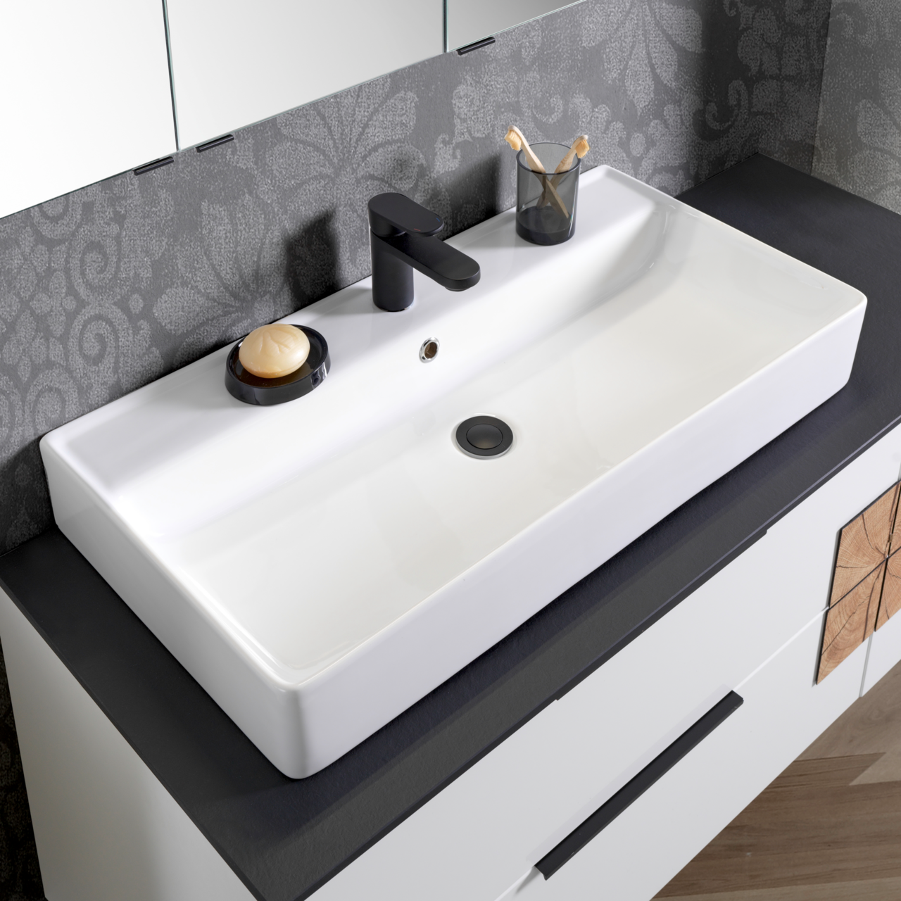 Moderner Waschtisch mit schwarzem Wasserhahn, Seifenschale und Zahnputzbecher, aus der Vogelperspektive fotografiert.