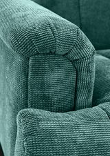 Nahaufnahme einer grünen, strukturierten Polsterung einer 2er-Sitzbank, Perspektive von der Armlehne.